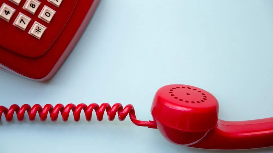 Red dialer phone kept on hold, depicting buying-time chat scripts